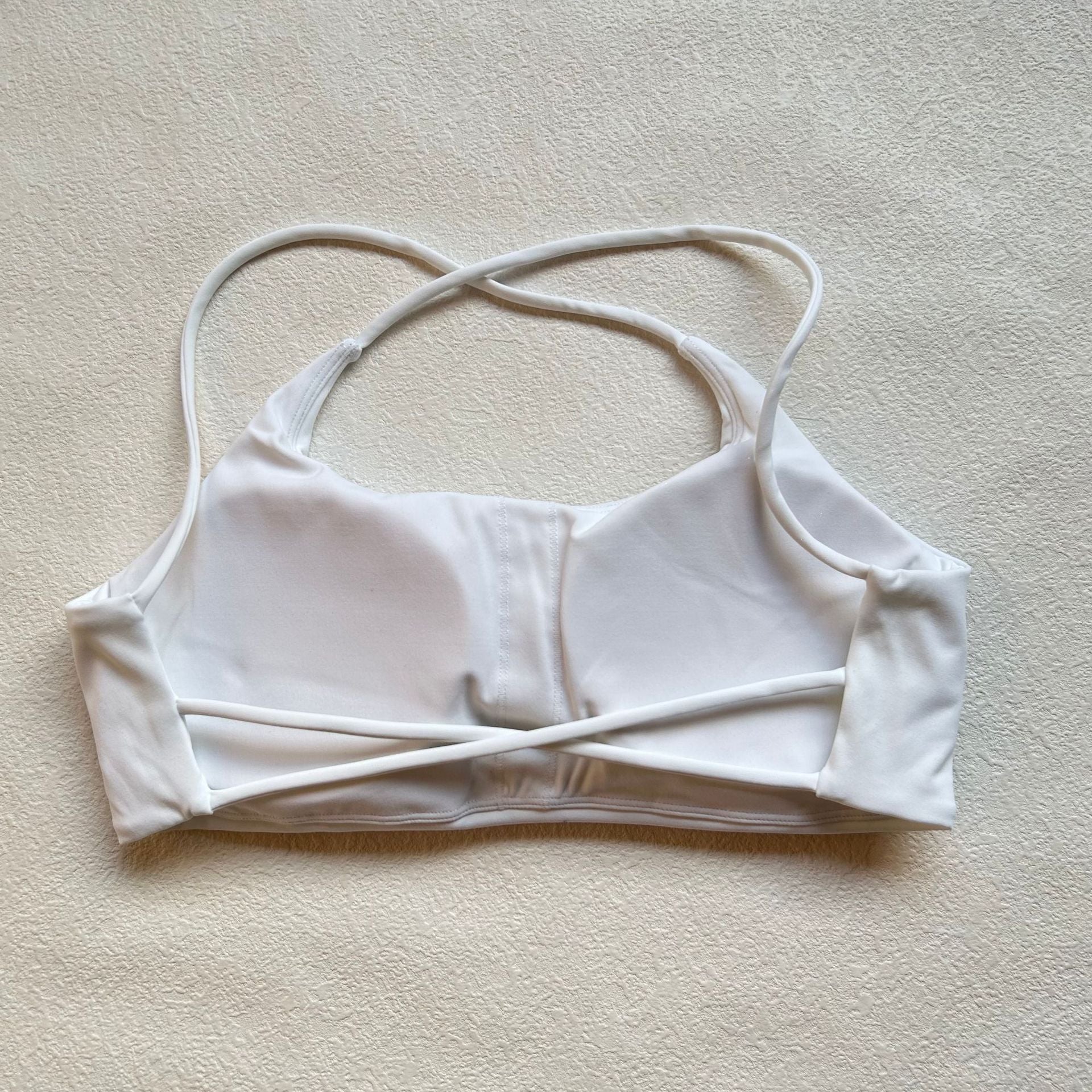 A nude fitness bra with thin straps and a cut-out back