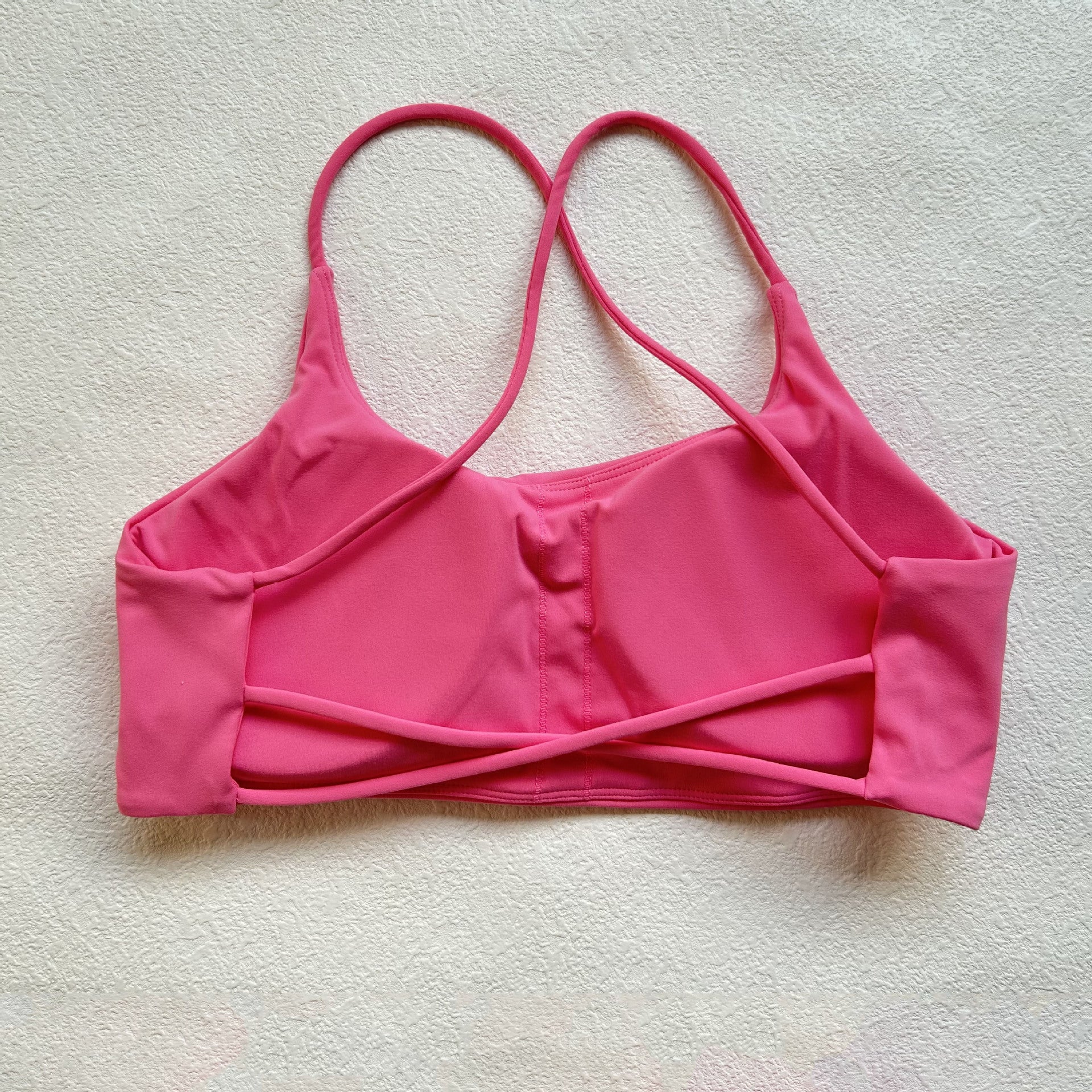 A nude fitness bra with thin straps and a cut-out back