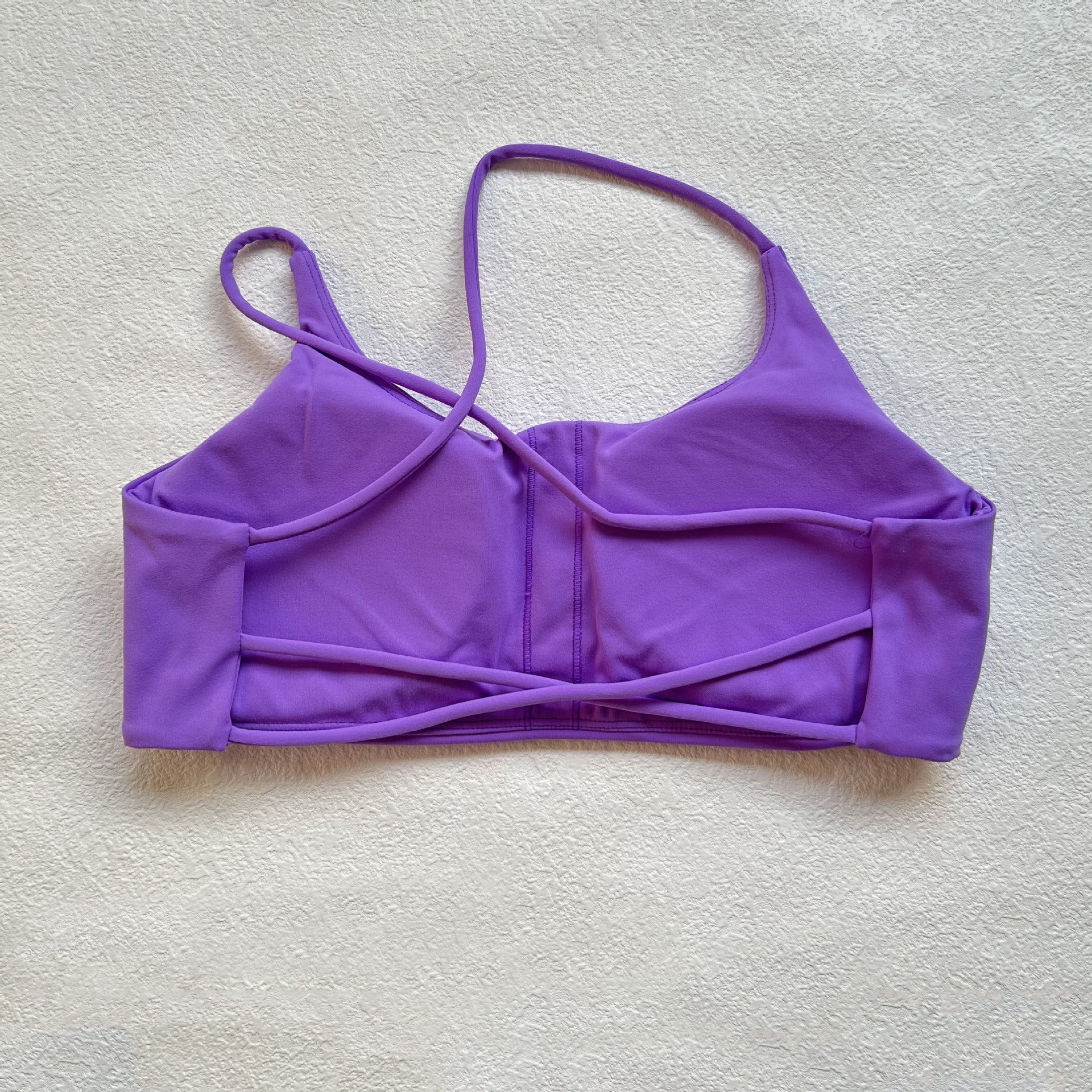 A nude fitness bra with thin straps and a cut-out back