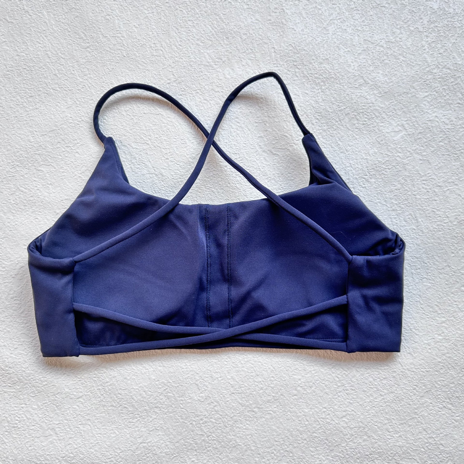 A nude fitness bra with thin straps and a cut-out back