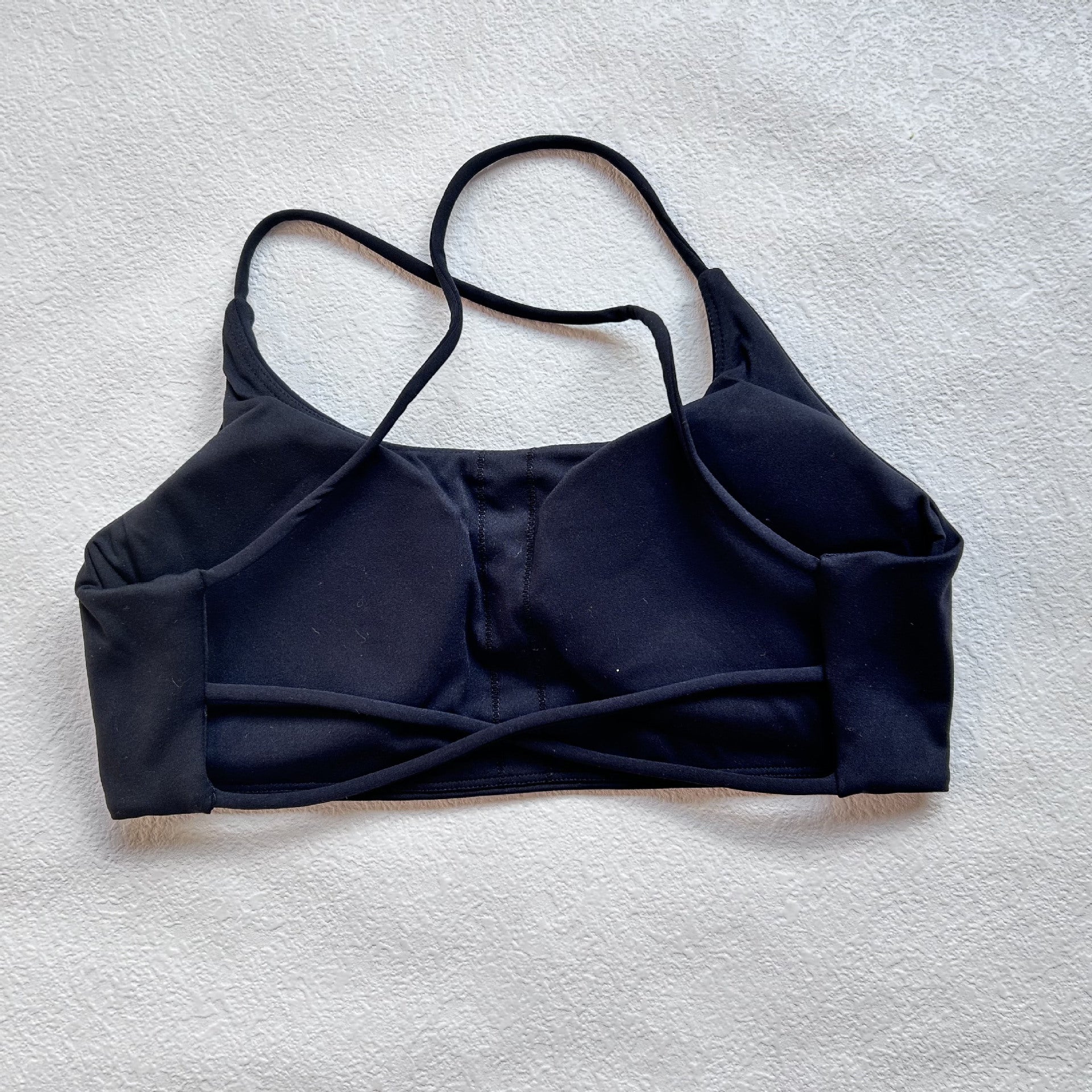 A nude fitness bra with thin straps and a cut-out back