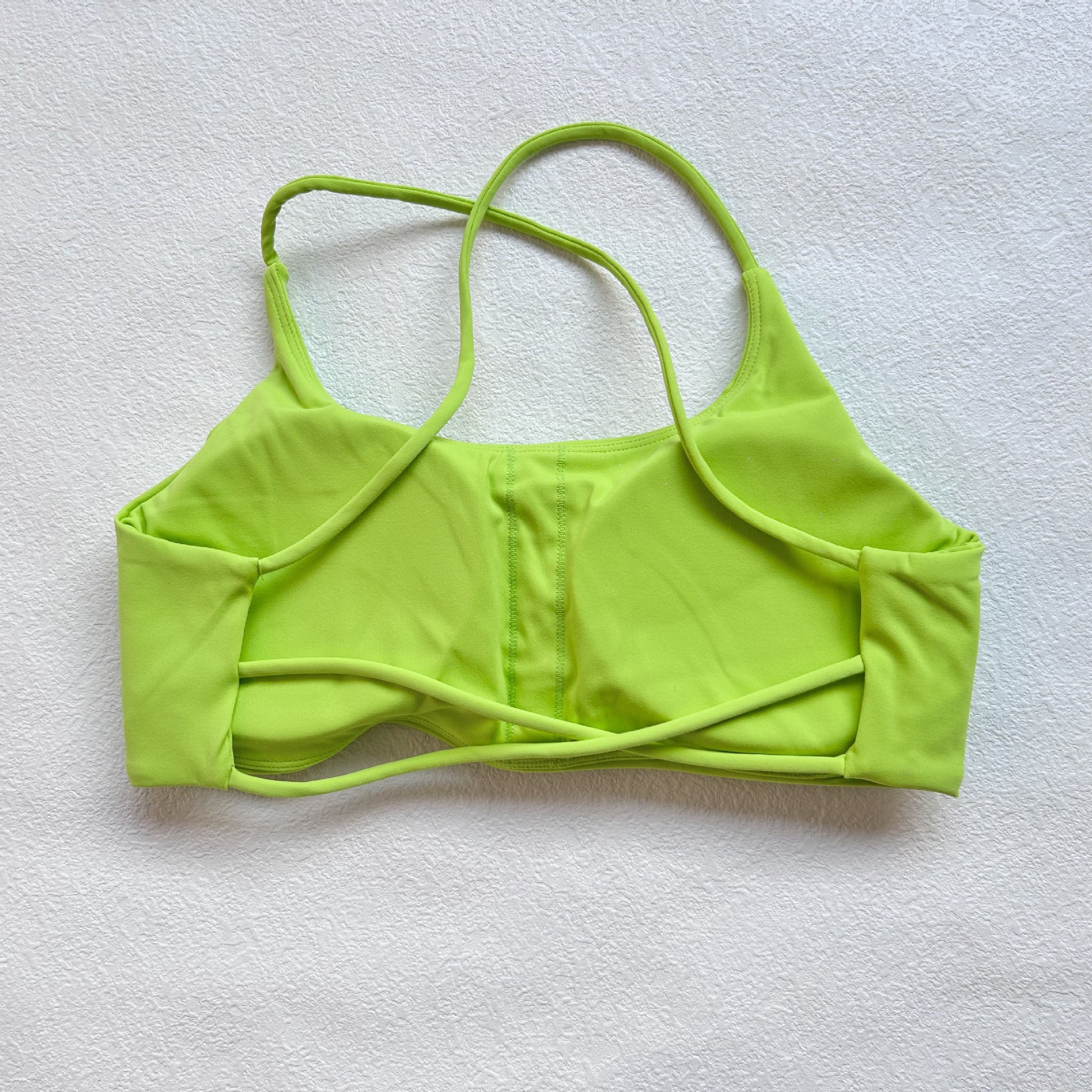 A nude fitness bra with thin straps and a cut-out back