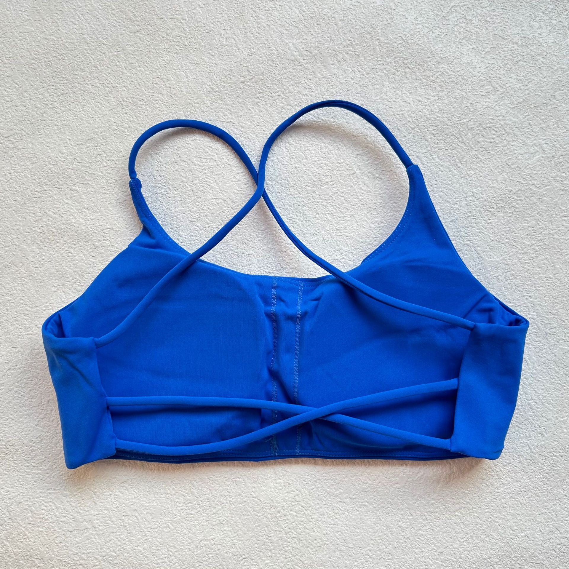 A nude fitness bra with thin straps and a cut-out back